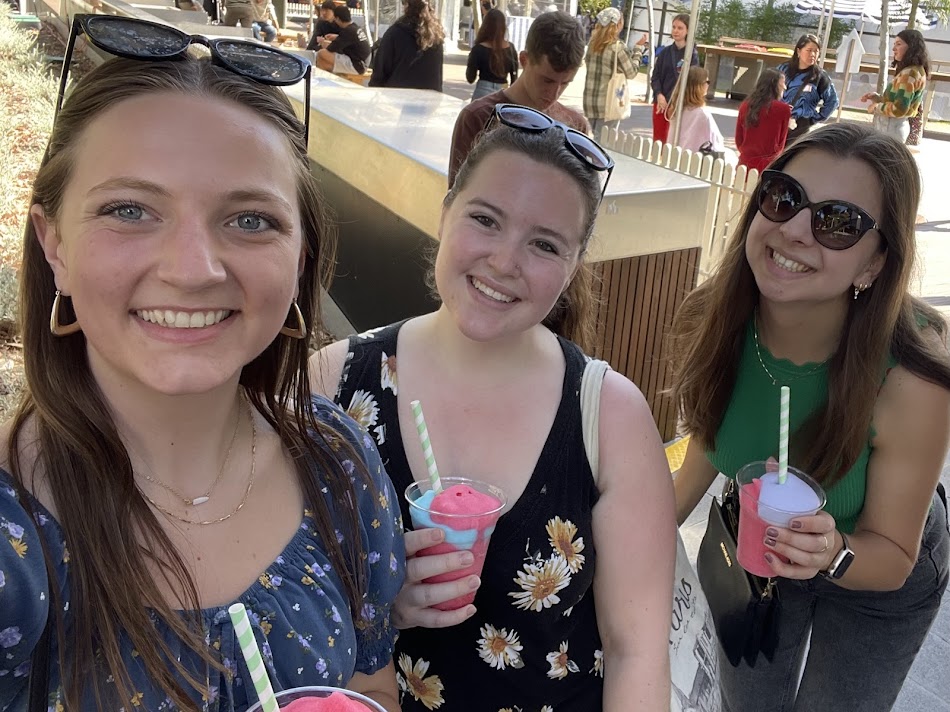 Three students smiling for a selfie, holding brightly-colored frozen slushies.