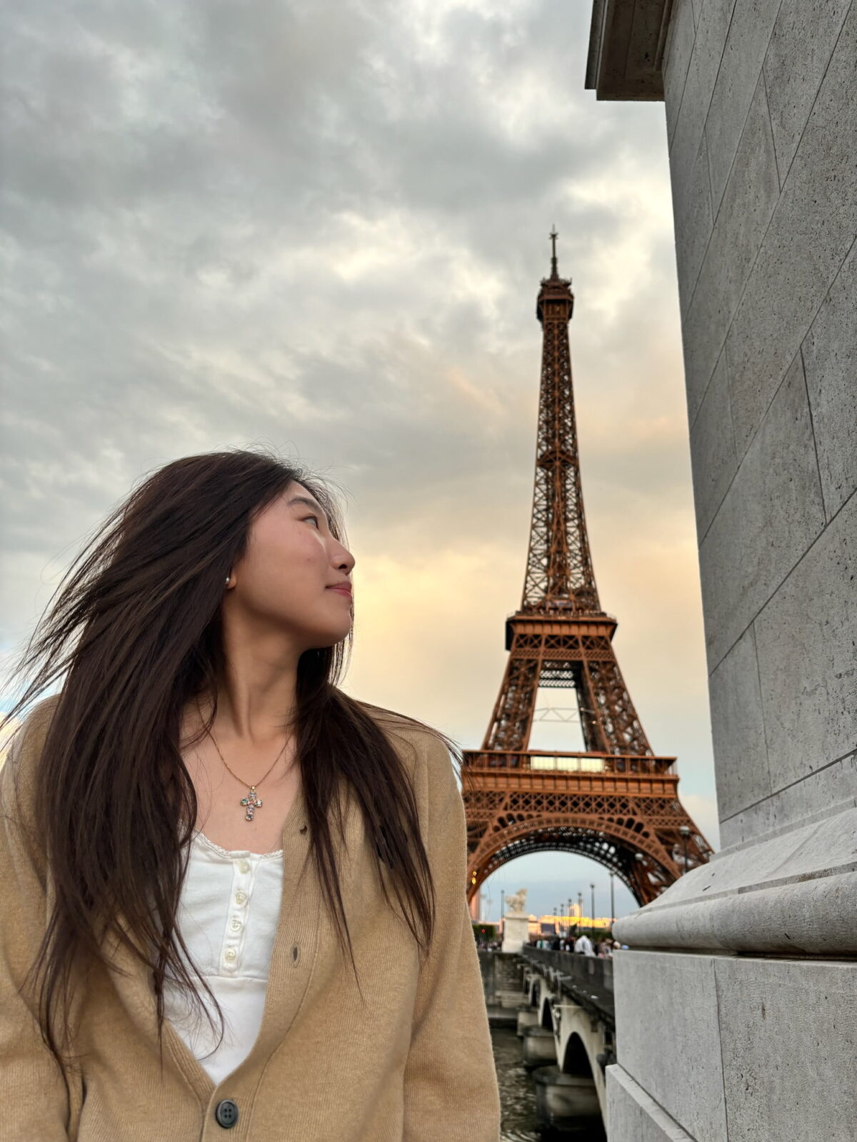 A student looking into the distance with the Eiffel Tower in the background.
